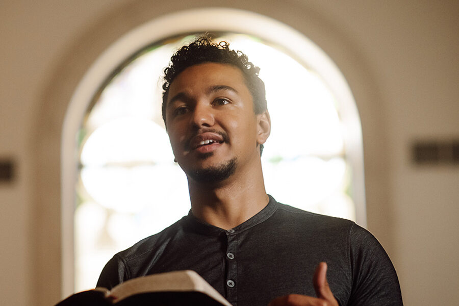 PBA student reads the bible at the front of chapel.